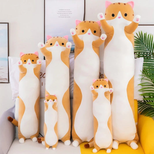 Set of cat-shaped plush pillows on a couch with a plant in the background
