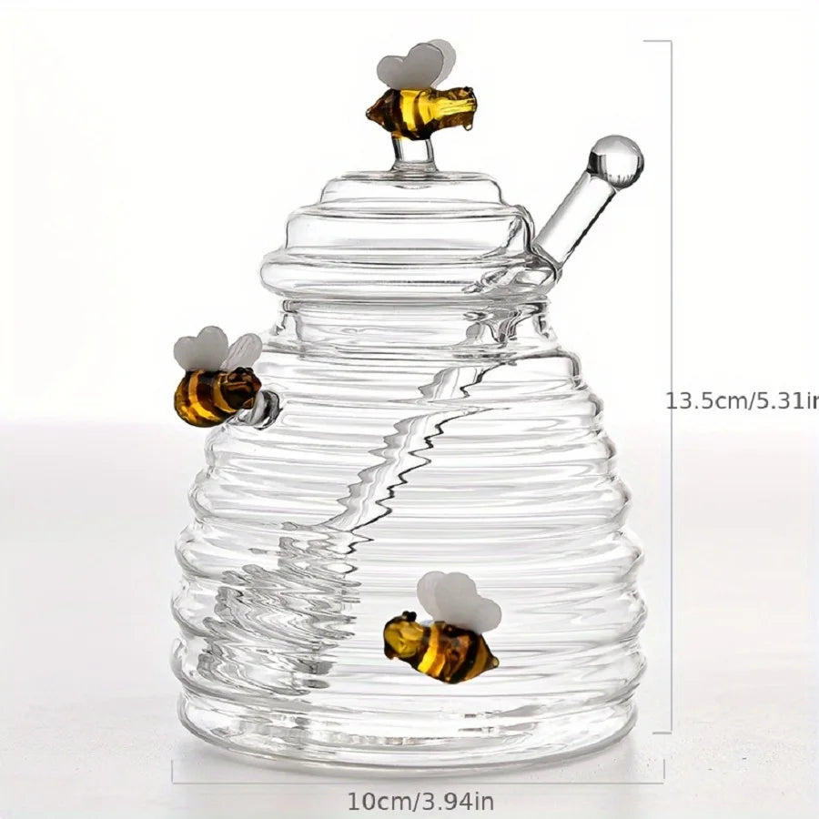 Glass honey dipper with bee decorations and measurements on a white background