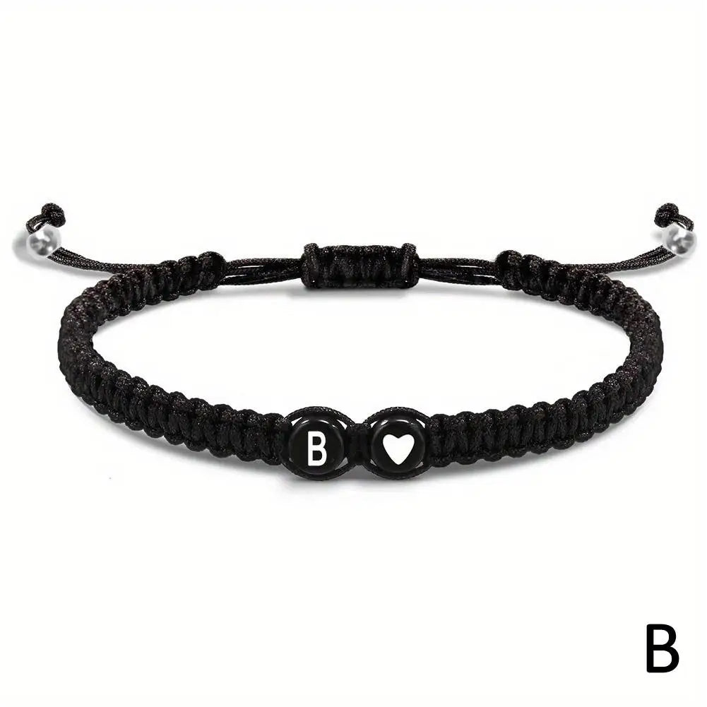 Black braided bracelet with letter 'B' and heart charm on a white background
