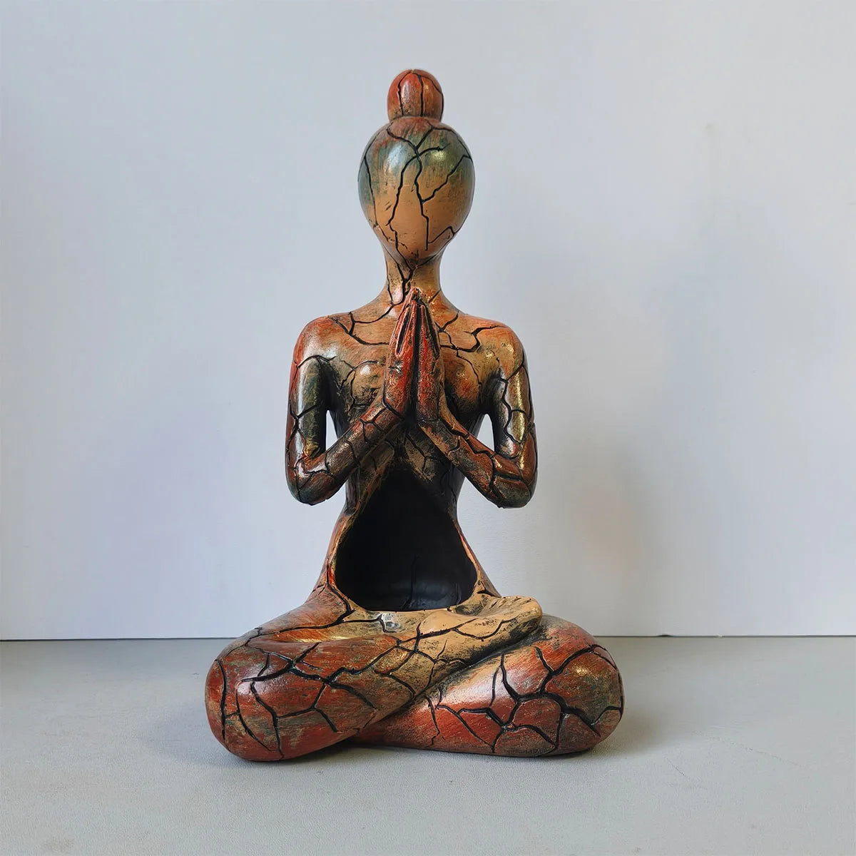 Artistic resin meditating figure ornament with a warm cracked-effect finish and hollow centre designed for a flameless LED candle.