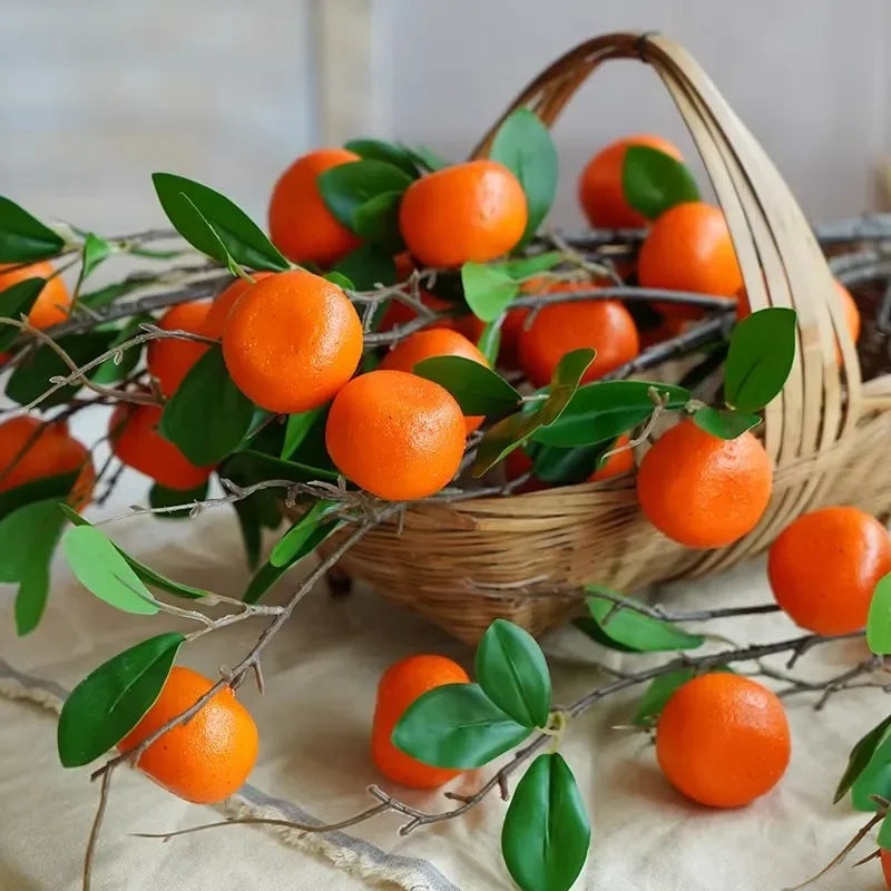 Basket of artificital orange stems with green leaves on a neutral background