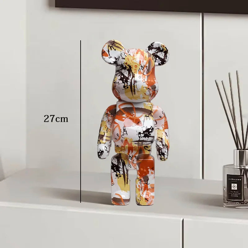 Decorative bear figure with abstract design on a white surface, next to a diffuser.