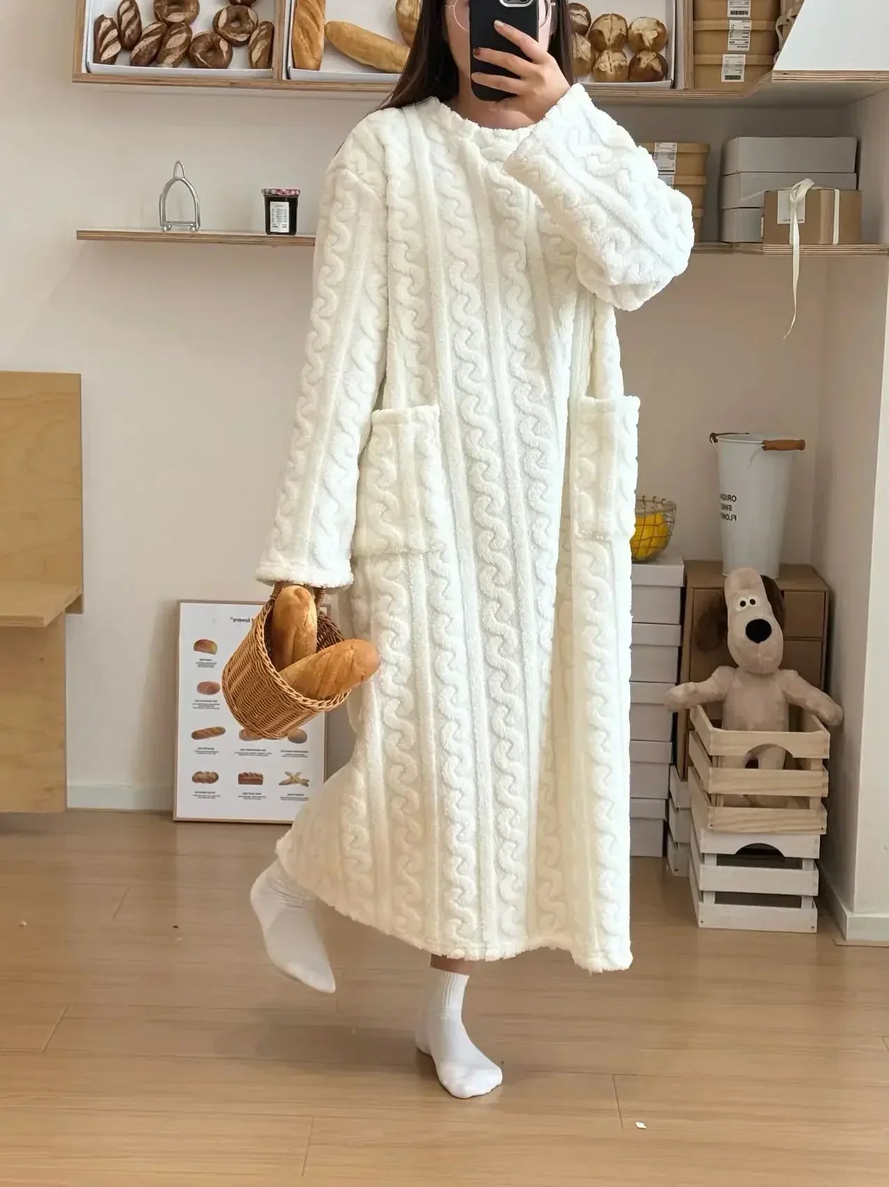 Person wearing a long, white textured robe in a room with shelves and toys.