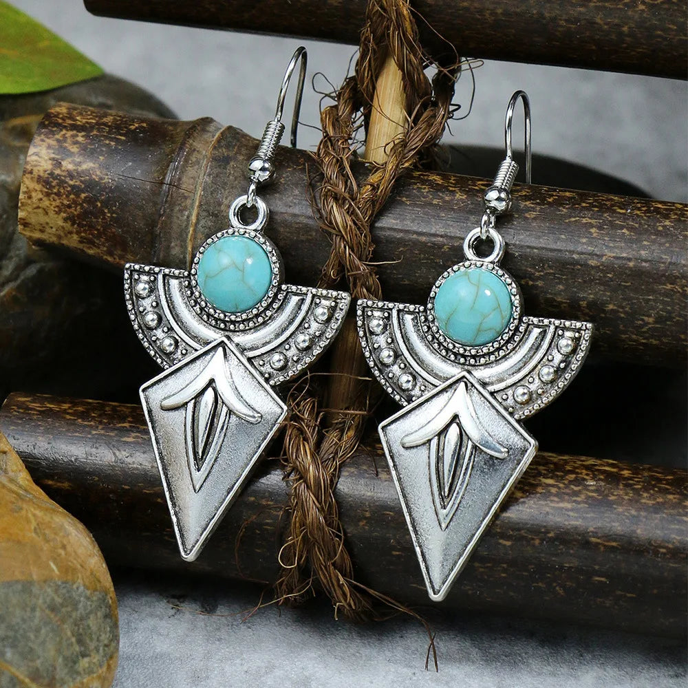 Pair of silver and turquoise earrings on a rustic background