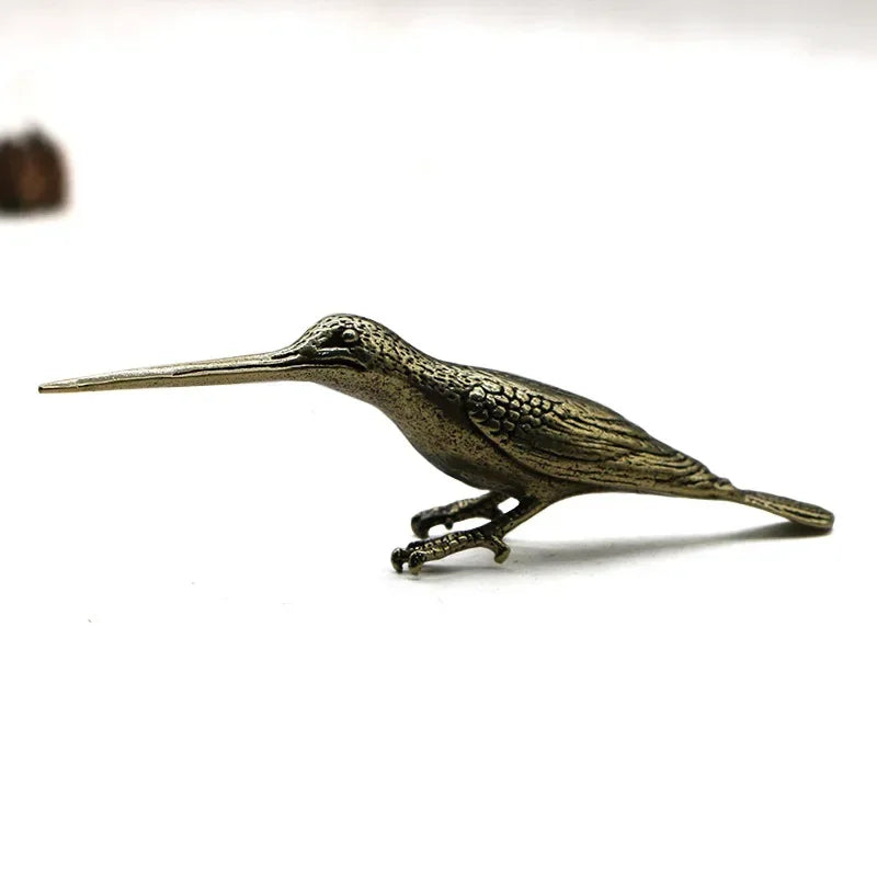 Bronze bird figurine on a white background