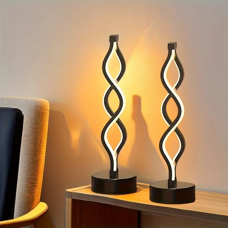 Modern LED spiral twist table lamp with warm ambient light on wooden surface.