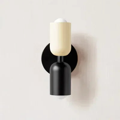Modern wall sconce with black base and white shade on a light gray background