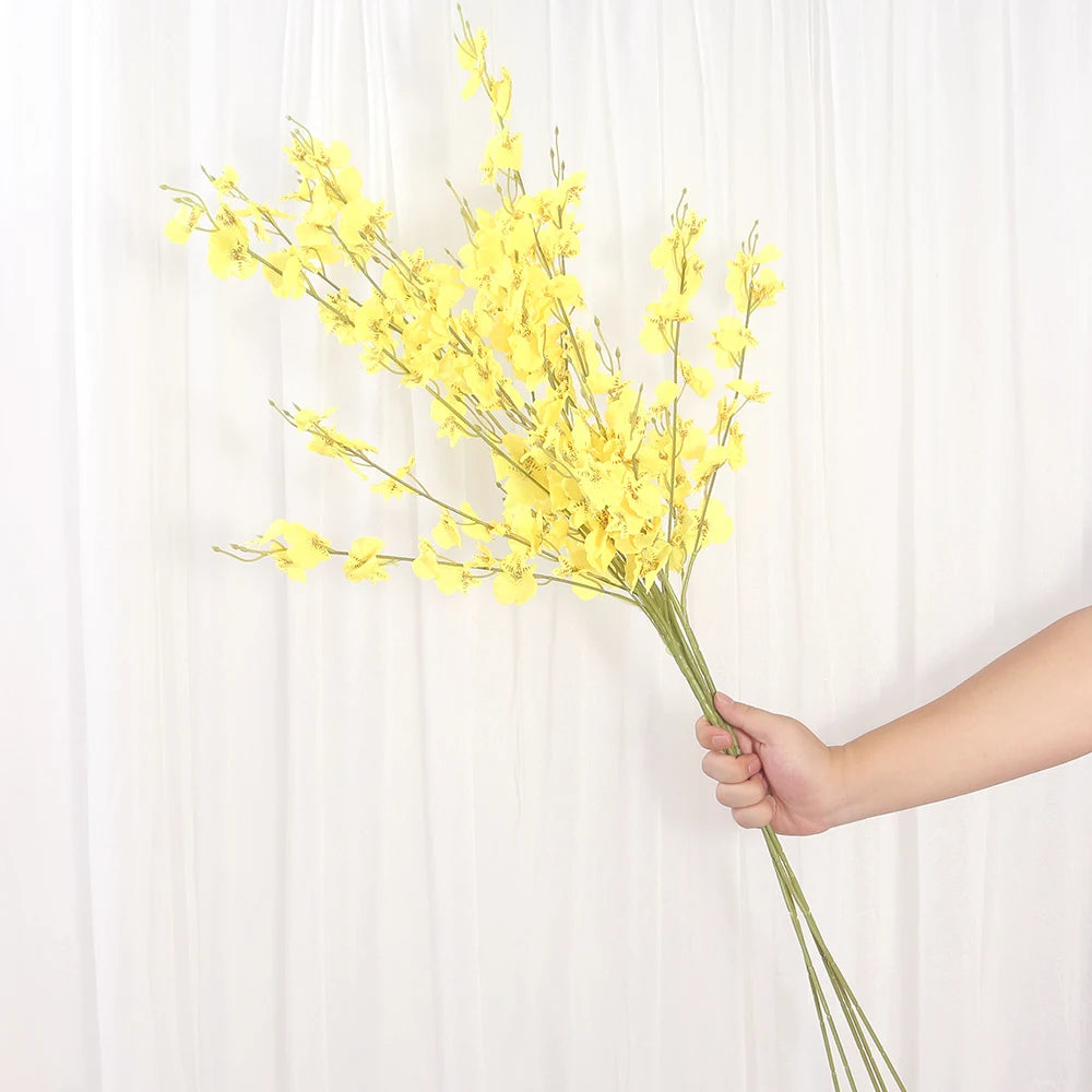 Hand holding a bouquet of yellow flowers against a white background