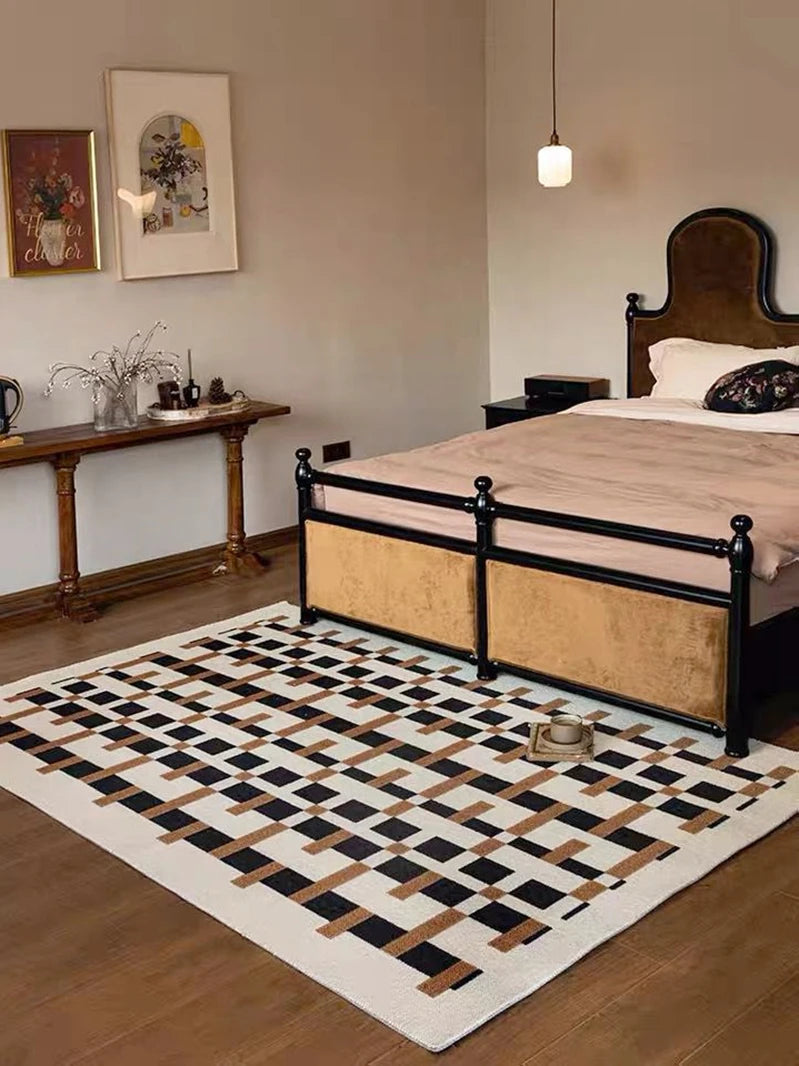 Bedroom with a checkered rug, bed, and desk.