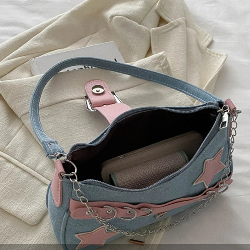 Blue handbag with pink star designs on a beige fabric background