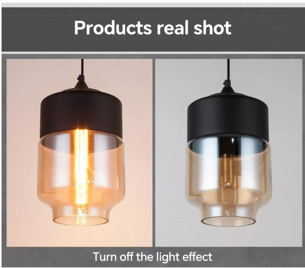 Two pendant lights with black and clear glass shades on a gray background.