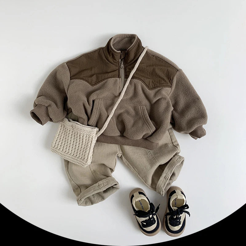 Children's brown fleece outfit with shorts, shoes, and a small bag on a white background