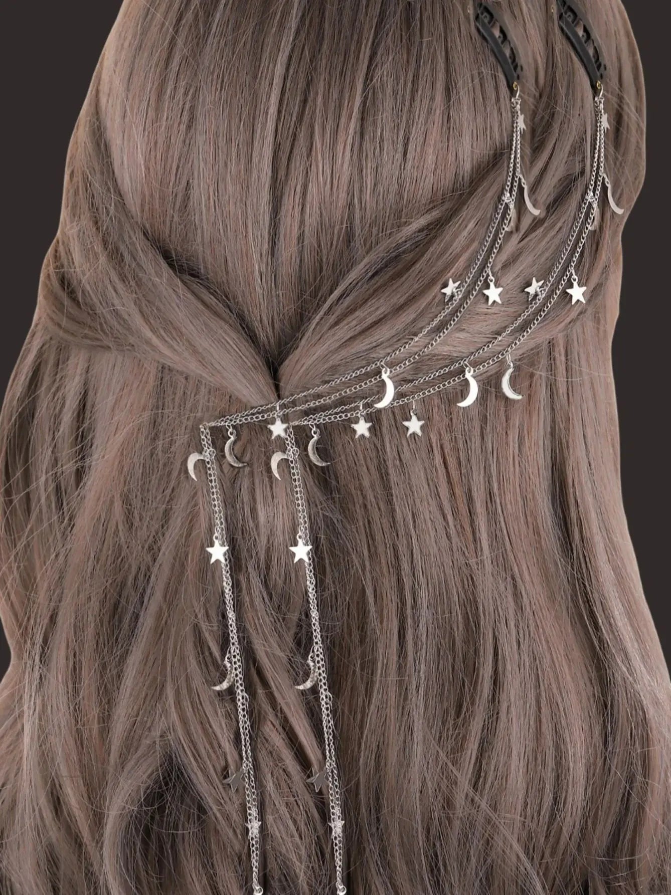 Hair accessory with star and moon designs on a person with long hair.
