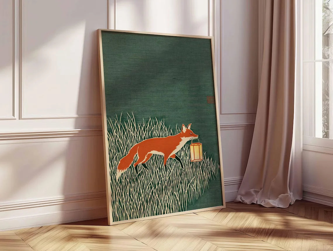 Minimalist Japanese-inspired fox art print showing an orange fox carrying a lantern through tall grass against a deep green background in a natural wood frame.