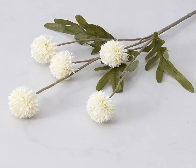 Artificial flower branch with white flowers and green leaves on a light gray background