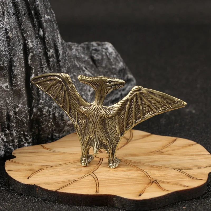 Solid brass pterosaur mini figurine on a wooden base with a dark background