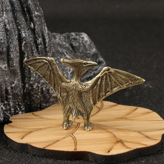 Solid brass pterosaur mini figurine on a wooden base with a dark background