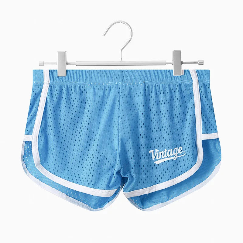 Blue mesh shorts with white trim on a hanger against a white background