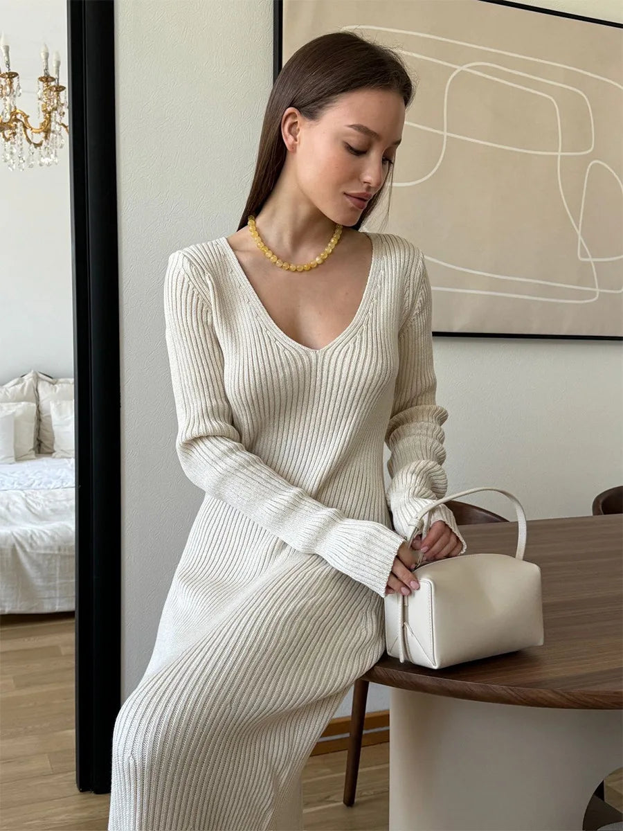 Woman wearing a cream ribbed knitted maxi dress with V-neck and long sleeves, Blubelle fashion in oatmeal