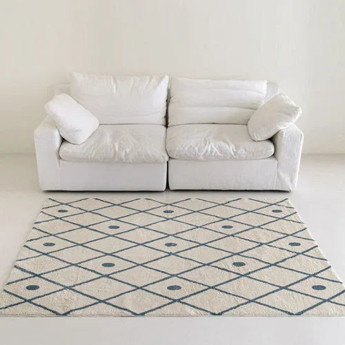 White sofa with patterned rug in a minimalistic room