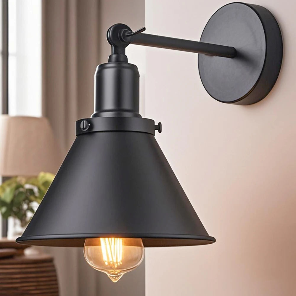 Black wall-mounted lamp with a lit bulb in a home setting