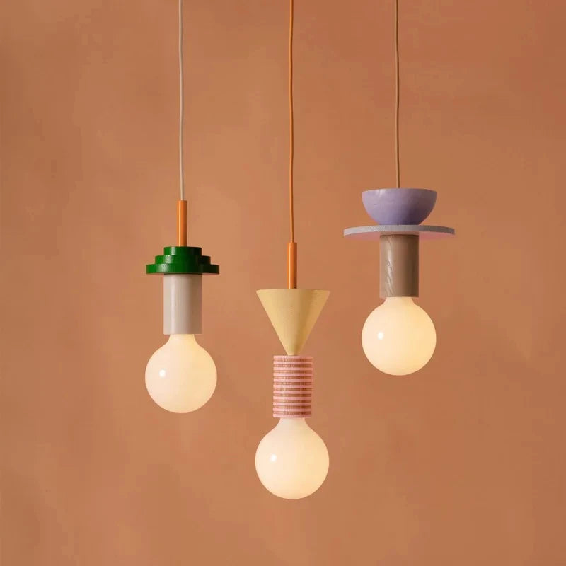 Three colorful pendant lights hanging against a brown background