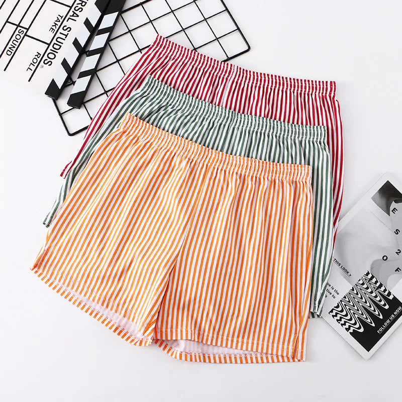 Three pairs of striped shorts in red, green, and orange on a white background.