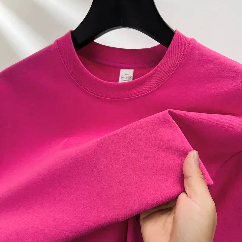 Pink sweatshirt on a hanger with a hand holding it, against a white background