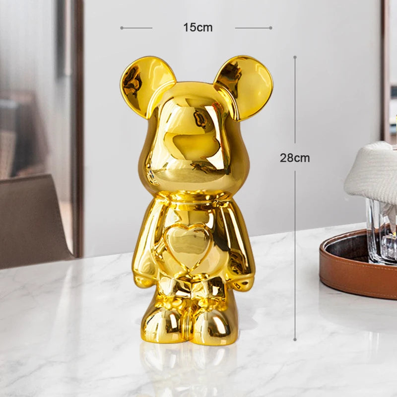 Gold teddy bear figurine with measurements on a white surface