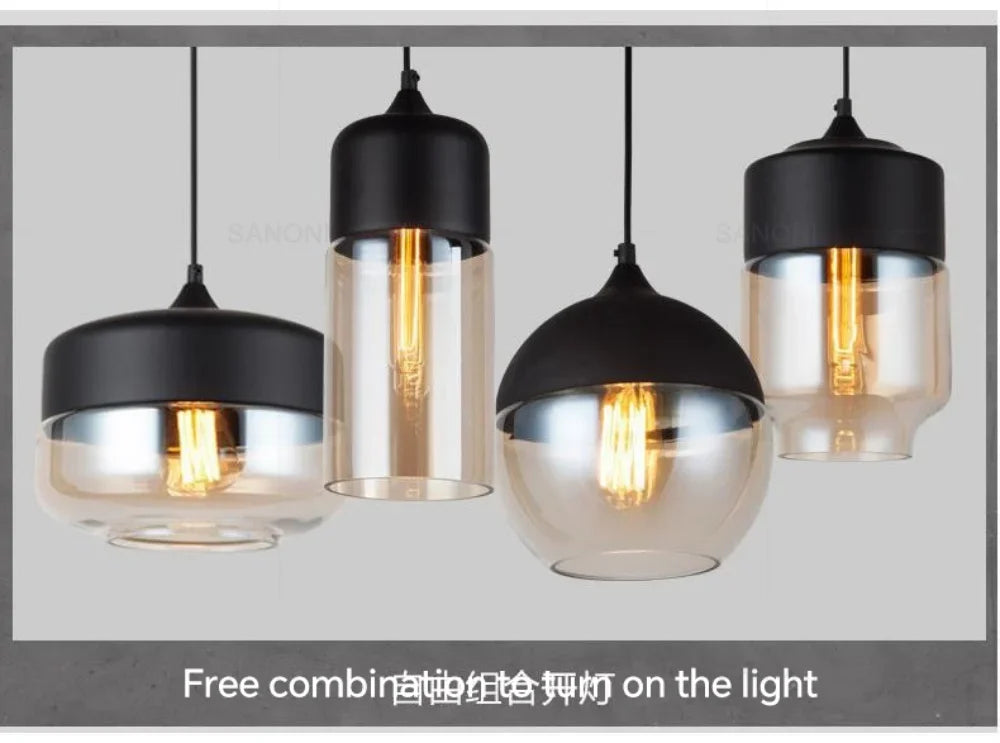 Set of four pendant lights with black and clear glass shades on a gray background.