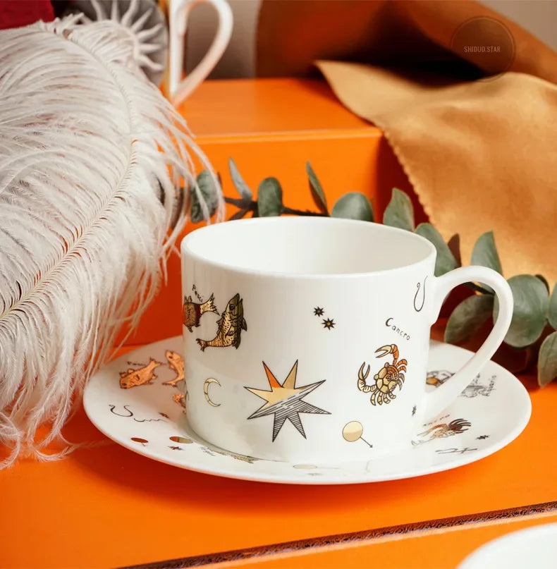 White mug with celestial design on an orange surface