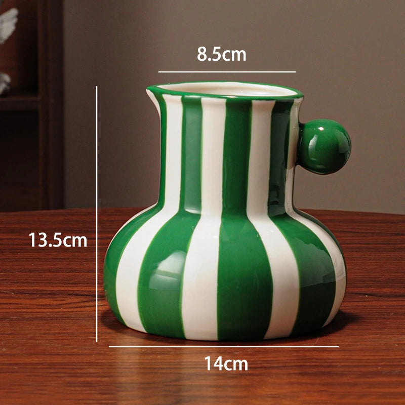 Green and white striped ceramic vase with measurements on a wooden surface