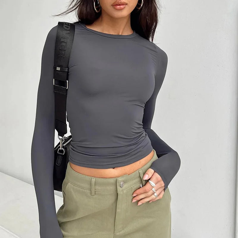 Woman wearing a slim fit long sleeve O-neck tee in a soft cotton blend.