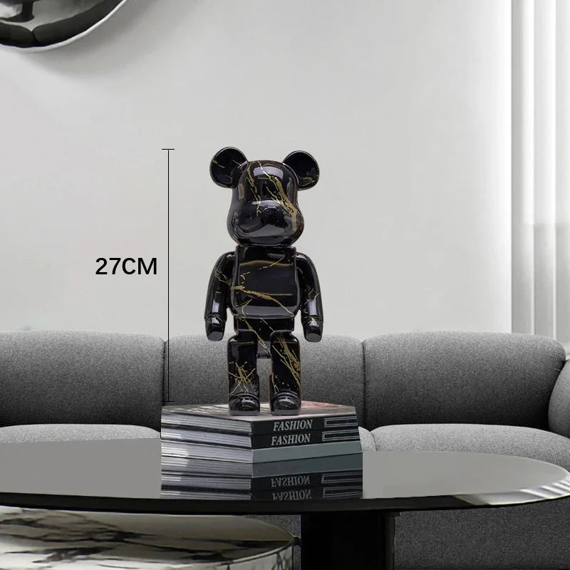 Black marble-patterned bear figure on a stack of books with dimensions indicated, placed on a table in a modern living room.