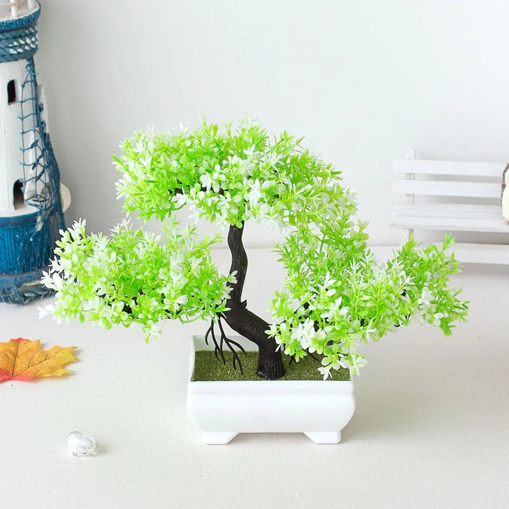 Artificial green bonsai tree in a white pot on a light surface.
