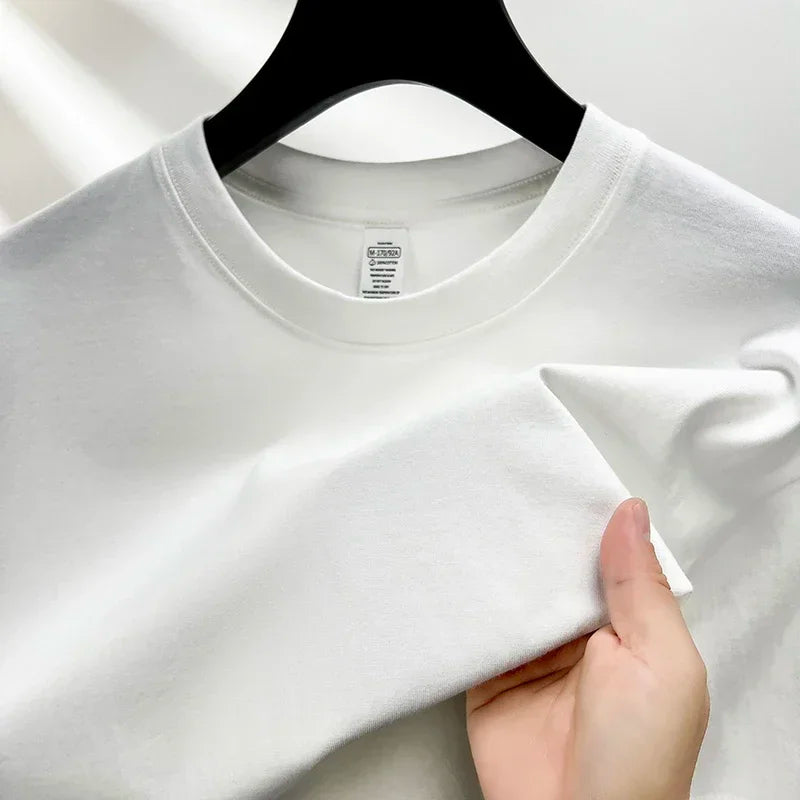 White t-shirt on a hanger with a hand touching it, on a white background