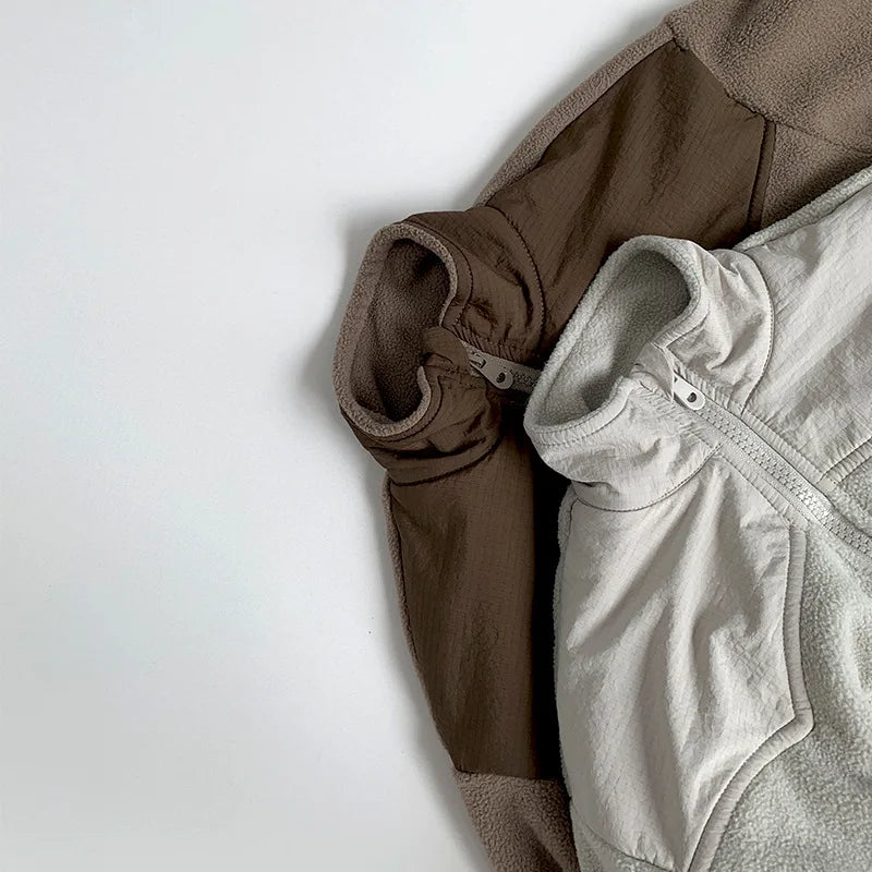 Two pieces of clothing, one brown and one gray, on a light gray background.