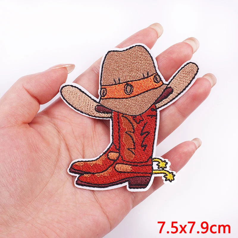 Cowboy hat and boot patch held by a hand on a white background