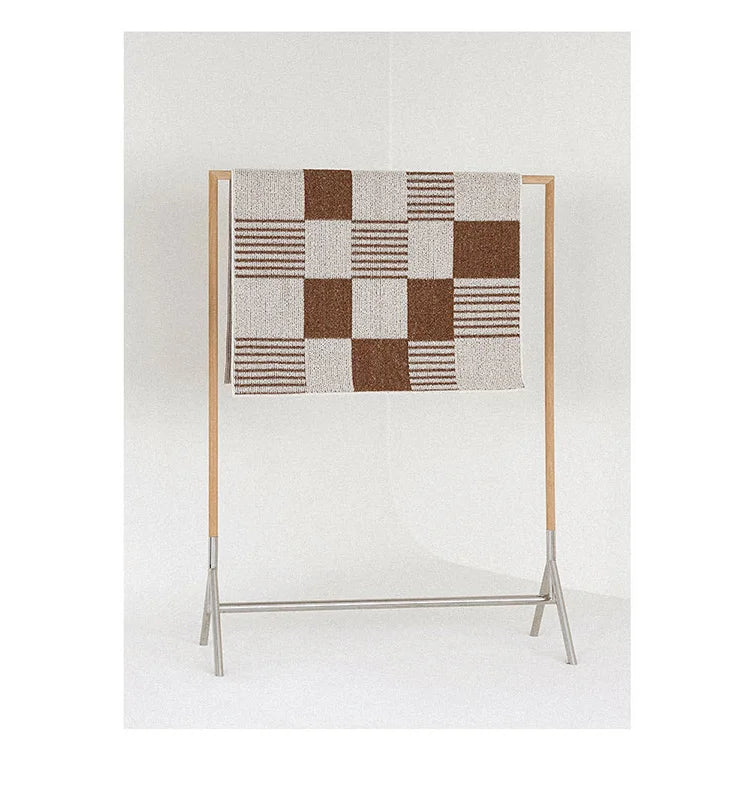 Checkered area rug with brown and beige pattern hunger over a rail