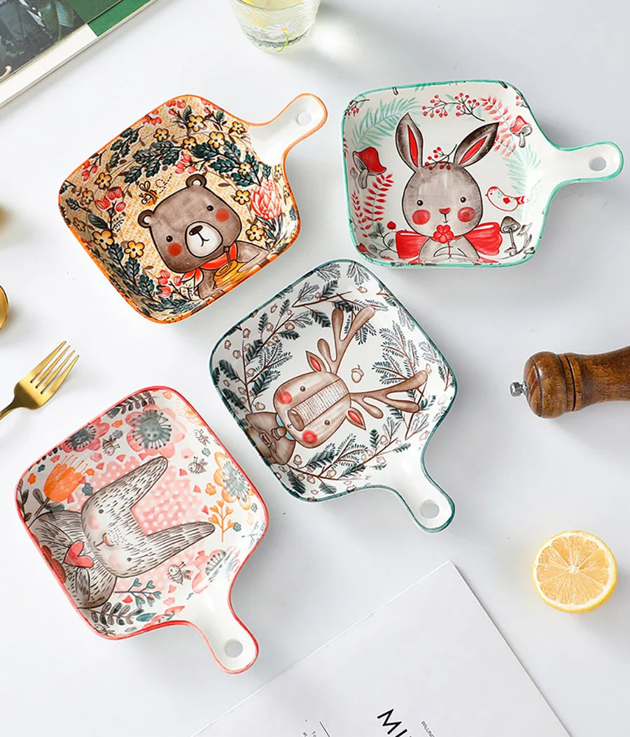 Set of four decorative plates with animal illustrations on a white surface.