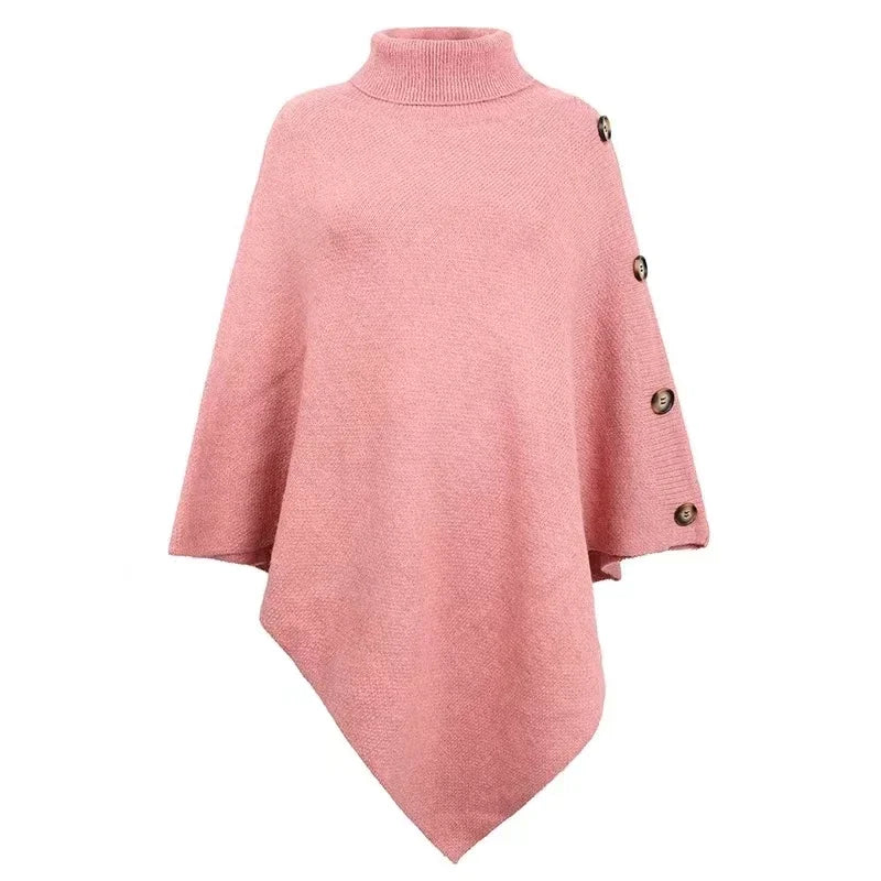 Women’s oversized pink poncho sweater with turtleneck and button sleeve detail styled with jeans
