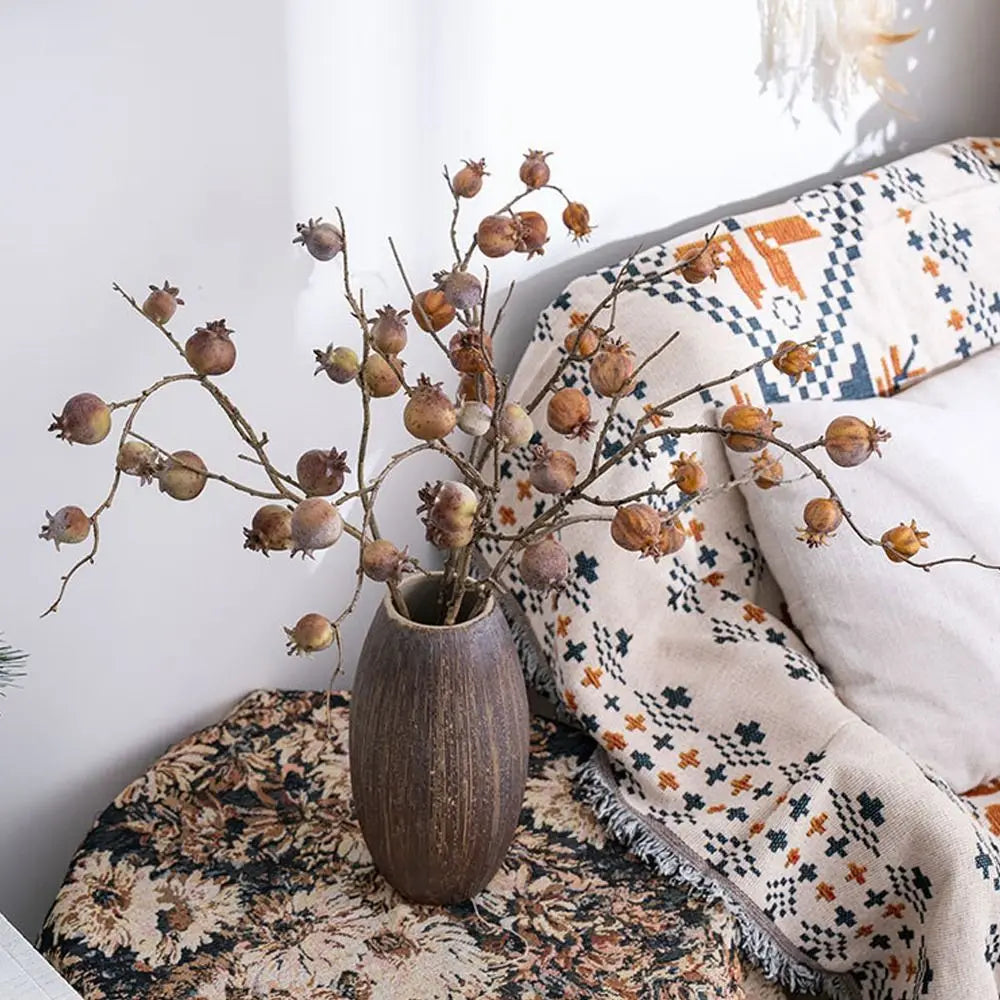 Decorative vase with dried branches on a patterned surface