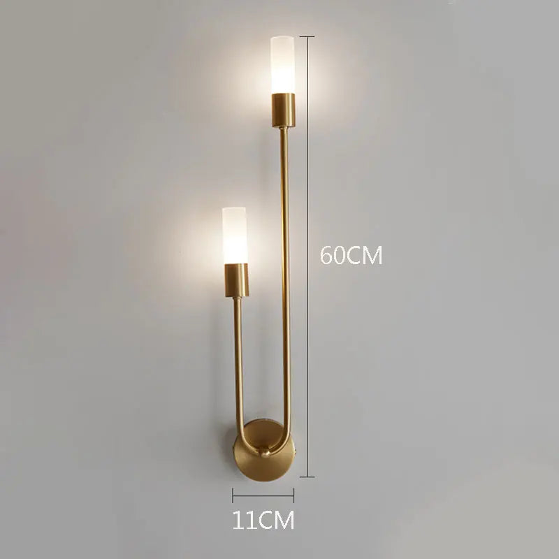 Gold wall sconce with measurements on a gray background