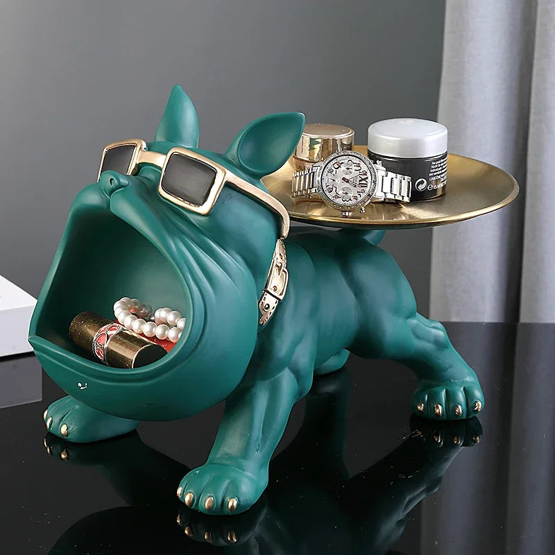 Teal bulldog-shaped jewelry holder with a gold tray on a dark surface.