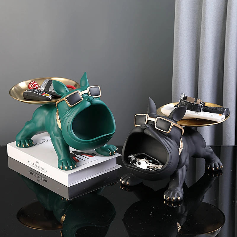 Two dog-shaped key holders with trays on a reflective surface.