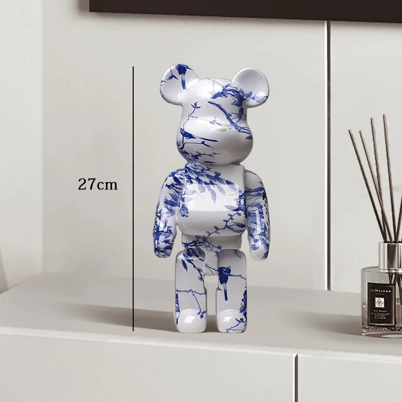 White bear figurine with blue floral patterns on a white surface, next to a diffuser.