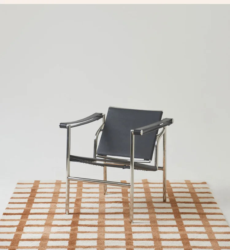 Modern chair with black seat and silver frame on a checkered rug