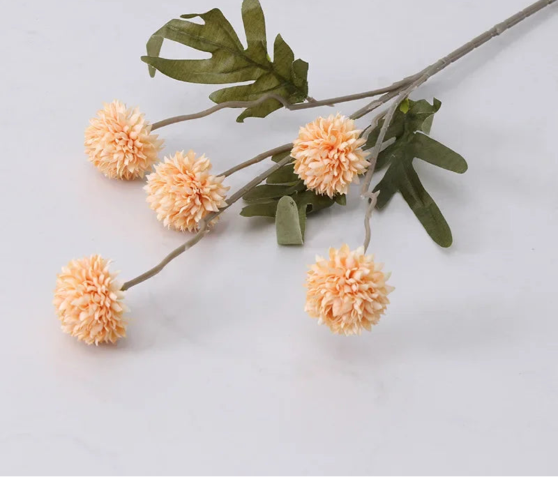 Branch with peach-colored flowers and green leaves on a light gray background
