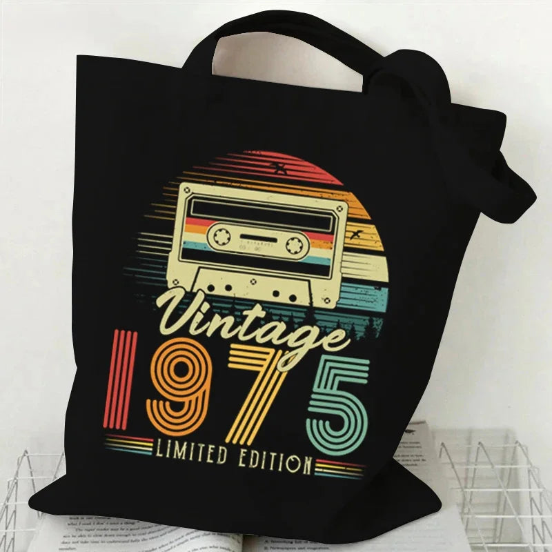 Black tote bag with a retro cassette design and 'Vintage 1975 Limited Edition' text on a white background.