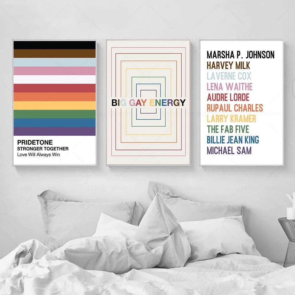 Three framed artworks on a wall above a bed with pillows.